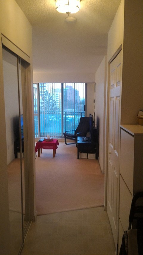 A hallway with a table and chairs in the background.