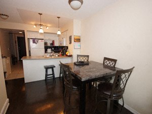 A kitchen with a table and chairs in front of it.