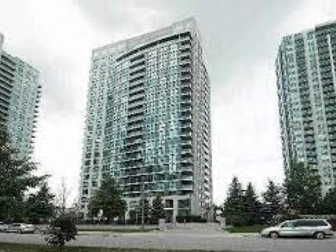 A large glass building stands between two smaller ones.