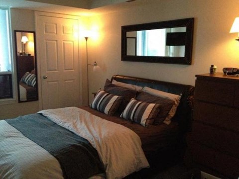 A bedroom with a bed, nightstand, and lamp.