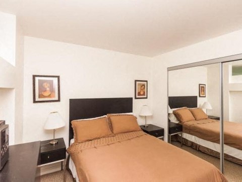 A bedroom with a bed, nightstand, and lamp.