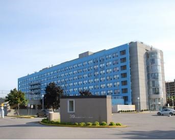 A large blue building with a grey sign in front of it.
