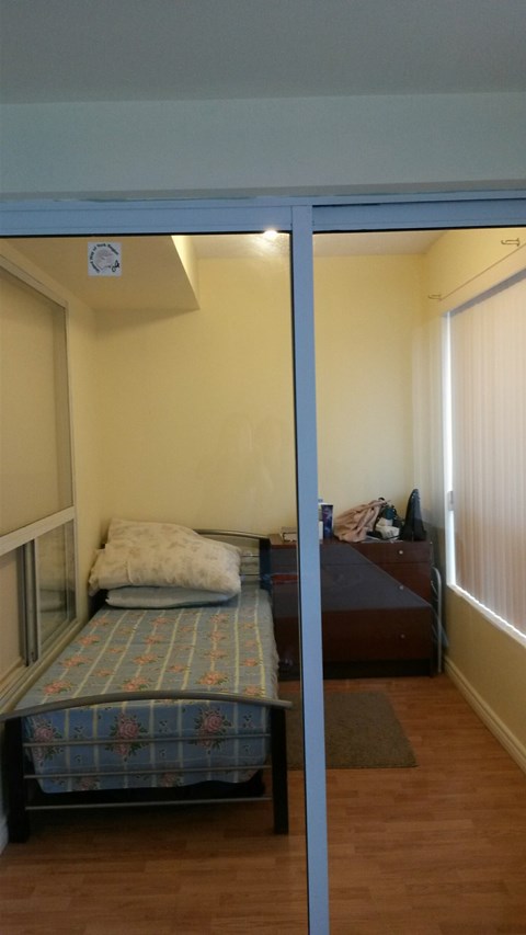 A bedroom with a bed and a window.