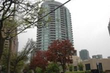A tall building with many windows is in the background of a cloudy day.