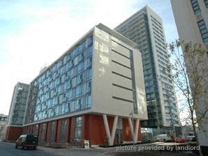 A modern building with a glass facade and a white and red exterior.