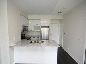 A kitchen with white cabinets and a white island.