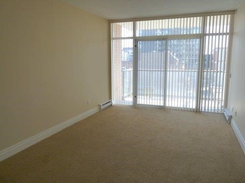 A room with a carpeted floor and a sliding glass door.