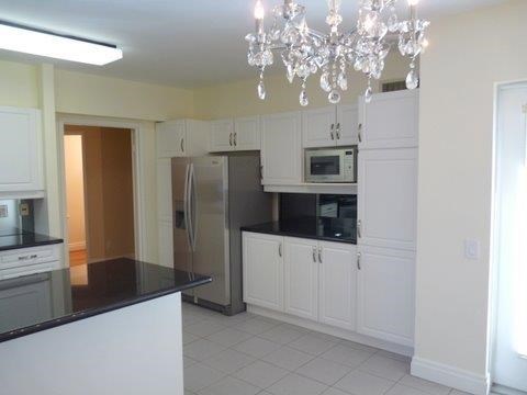 a kitchen with white cabinets and a stainless steel refrigerator