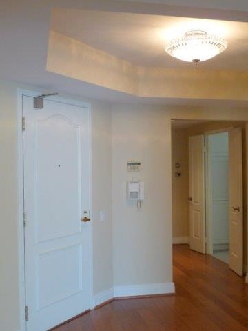 an empty room with a white door and a hallway