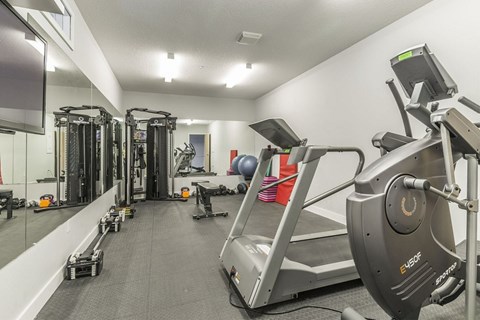 A gym with treadmills, weights, and exercise equipment.
