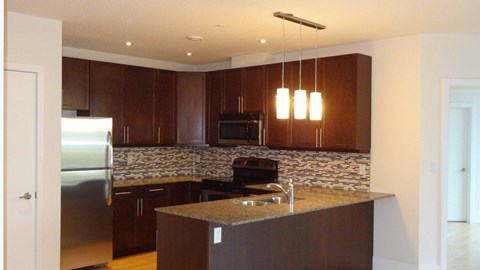 A kitchen with brown cabinets and a granite countertop.