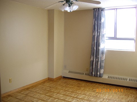 A room with a window and a ceiling fan.