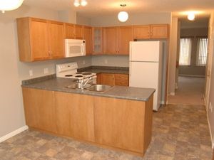 A kitchen with wooden cabinets and a white refrigerator.