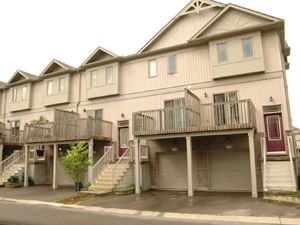 A two story house with a red door and a balcony.