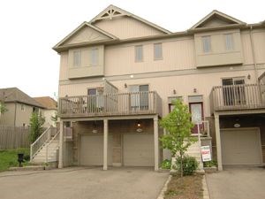 A two story beige house with a balcony on the second floor.