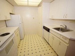 A kitchen with white cabinets and a yellow floor.