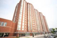 A tall red building with many windows is the main focus of the image.