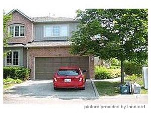 A red car is parked in front of a house.