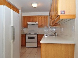 A kitchen with wooden cabinets and a white fridge.
