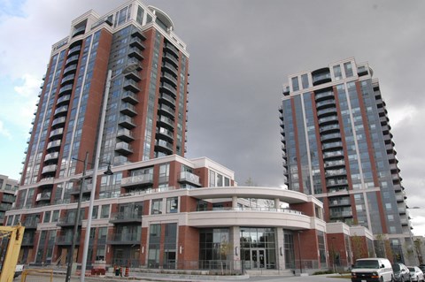Two modern high-rise buildings with balconies and glass windows.