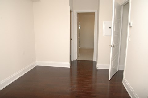 A hallway with a wooden floor and two doors.