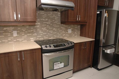 A kitchen with a stove top oven and a refrigerator.