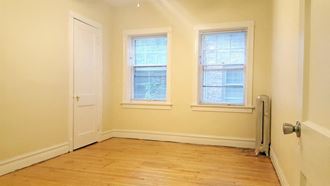a empty room with two windows and a door
