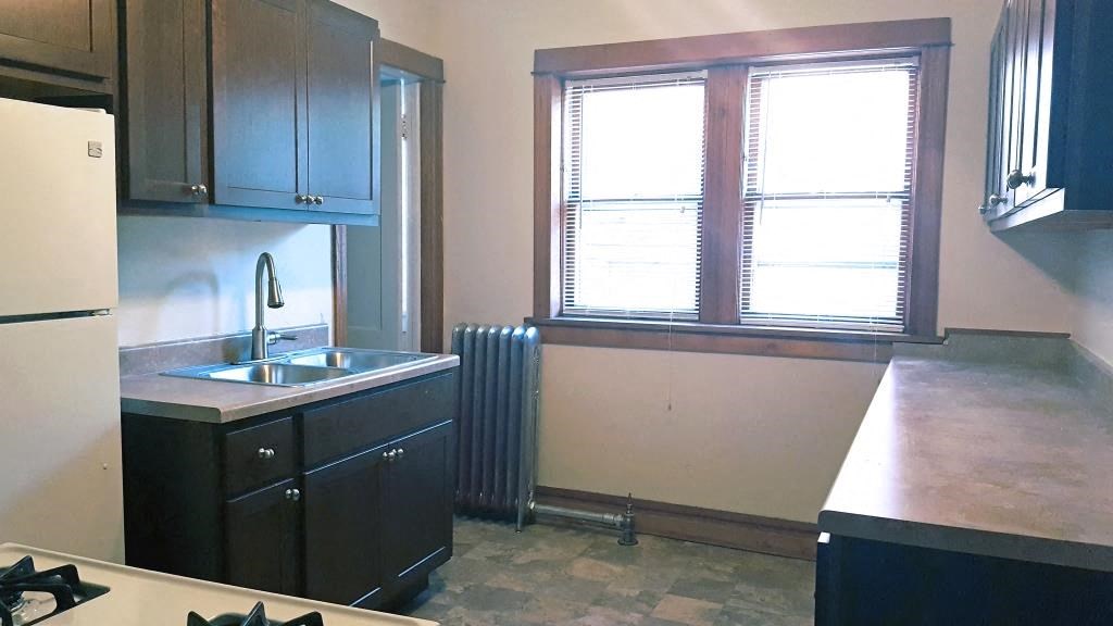 an empty kitchen with a sink and a window