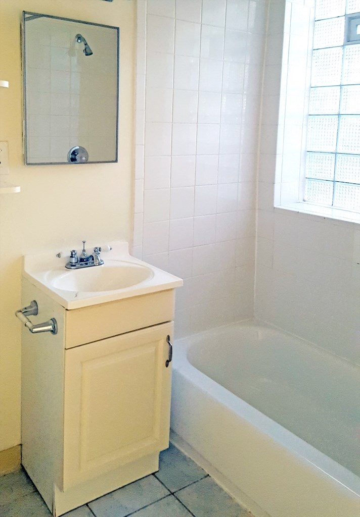 a bathroom with a sink and a tub and a mirror