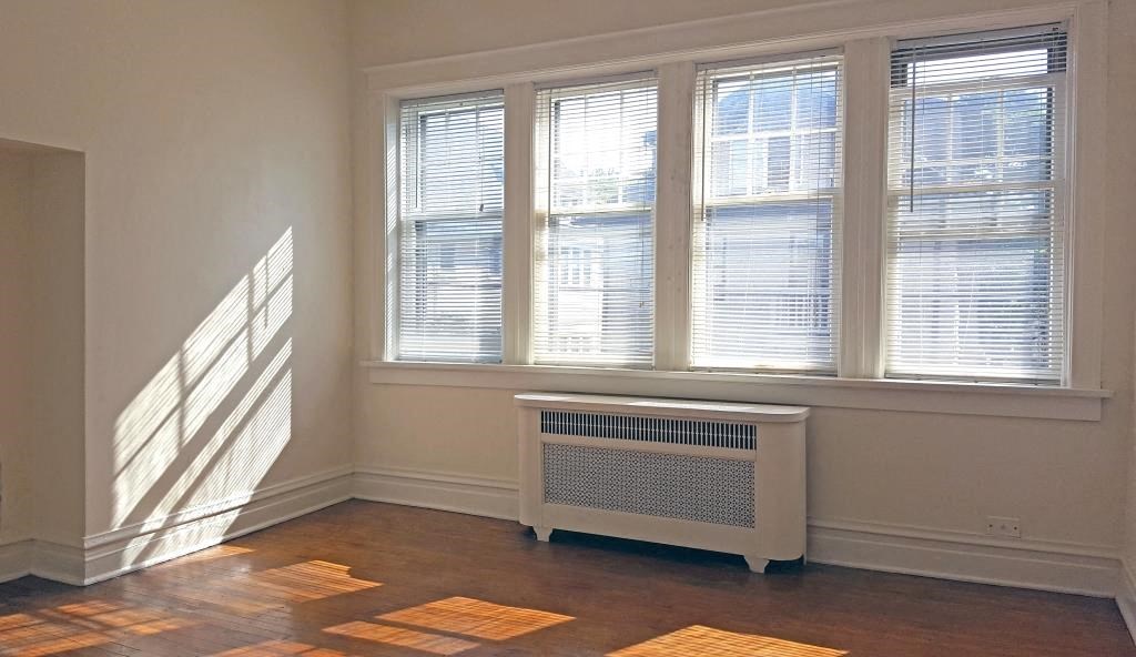 a room with a radiator and three windows