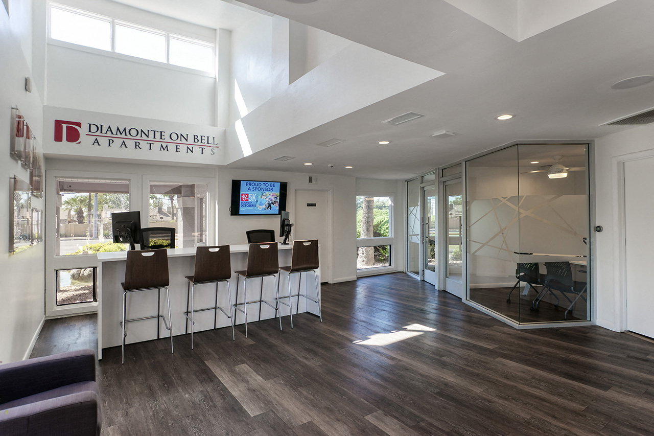 a room with a bar and chairs in front of a glass door