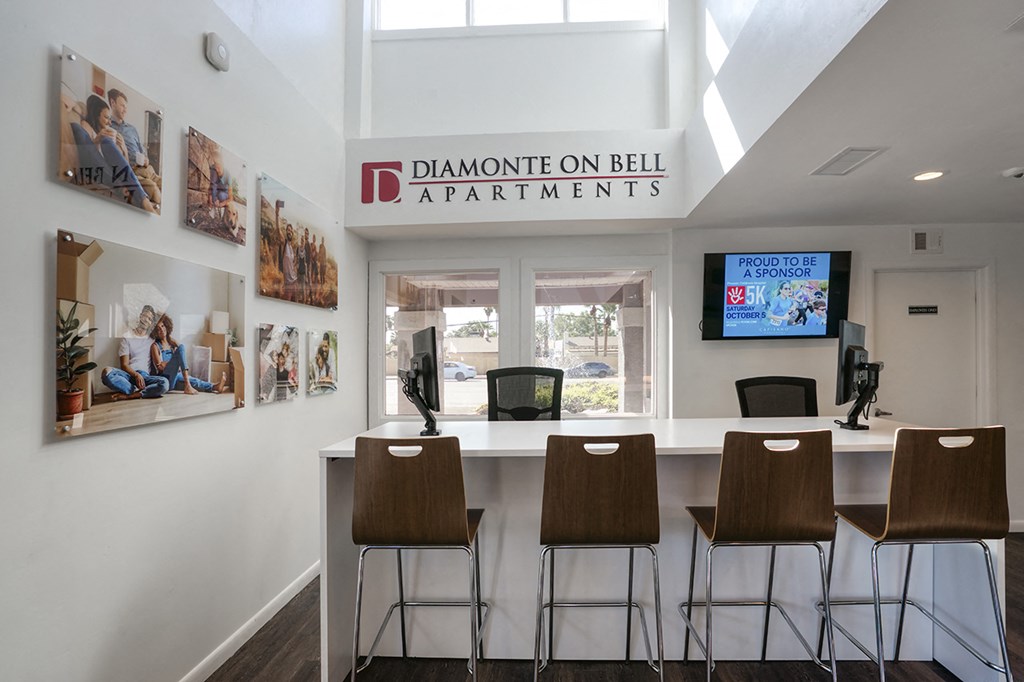 a bar with four stools in front of a window with a television