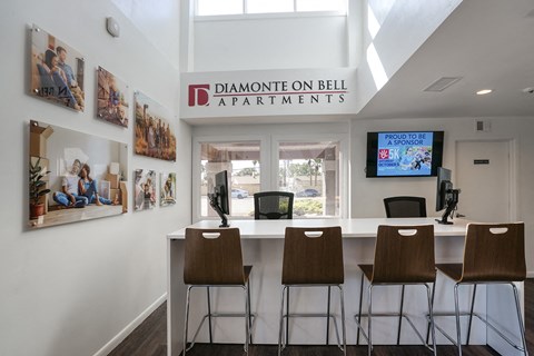 a bar with four stools in front of a window with a television