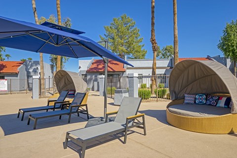 a patio with chairs and umbrellas and tables and chairs