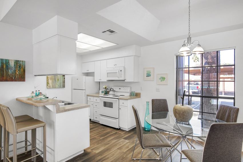 a kitchen and dining room with a glass table and chairs