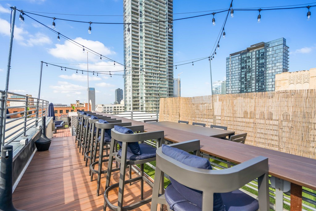 a rooftop bar with a view of the city and chairs and tables