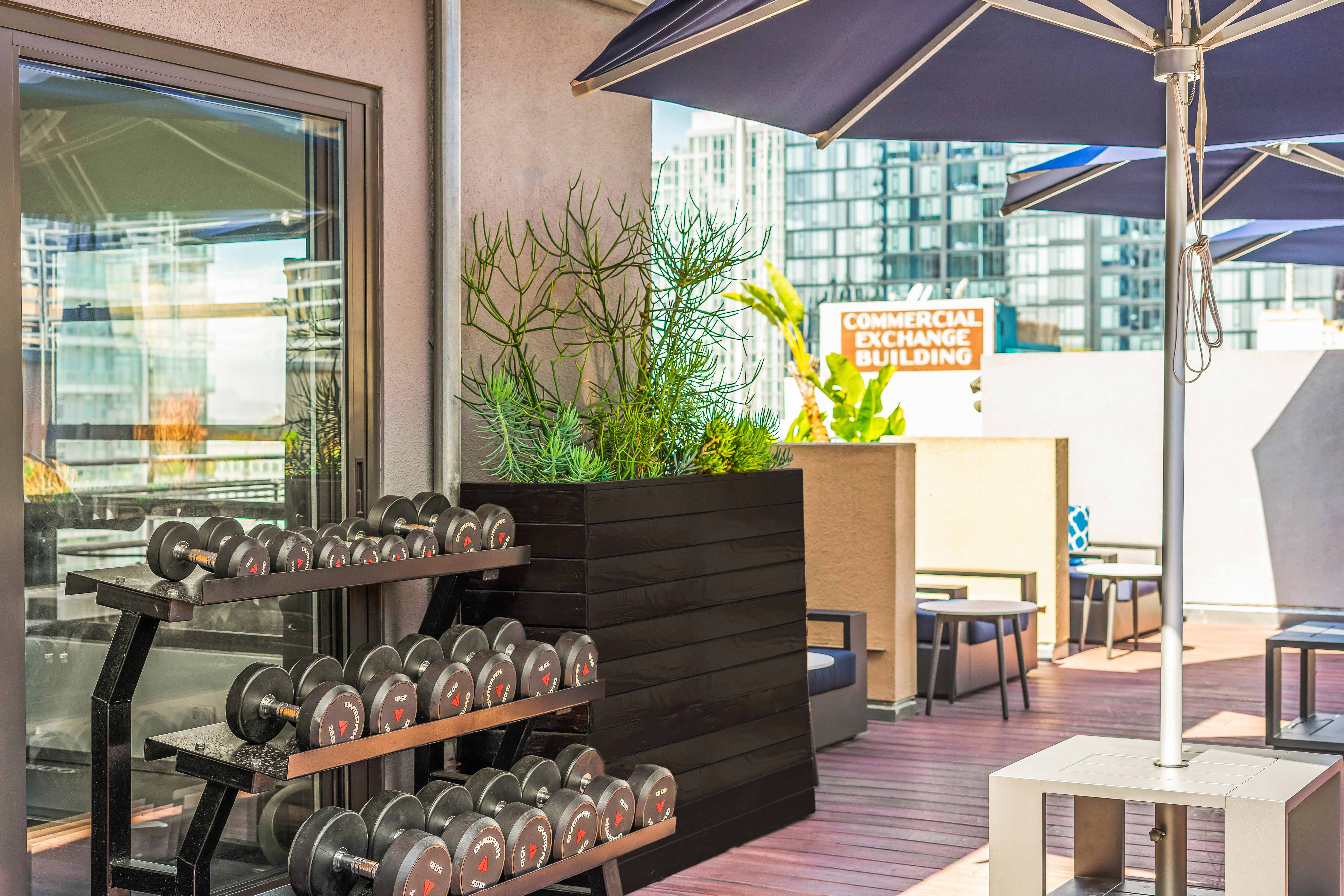 a fitness center with weights and a table with umbrellas
