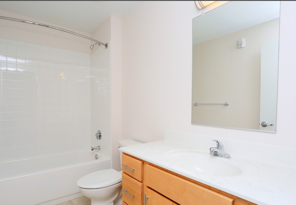 a bathroom with a sink toilet and shower and a mirror
