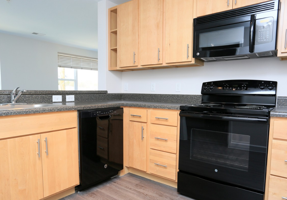 a kitchen with black appliances and wooden cabinets