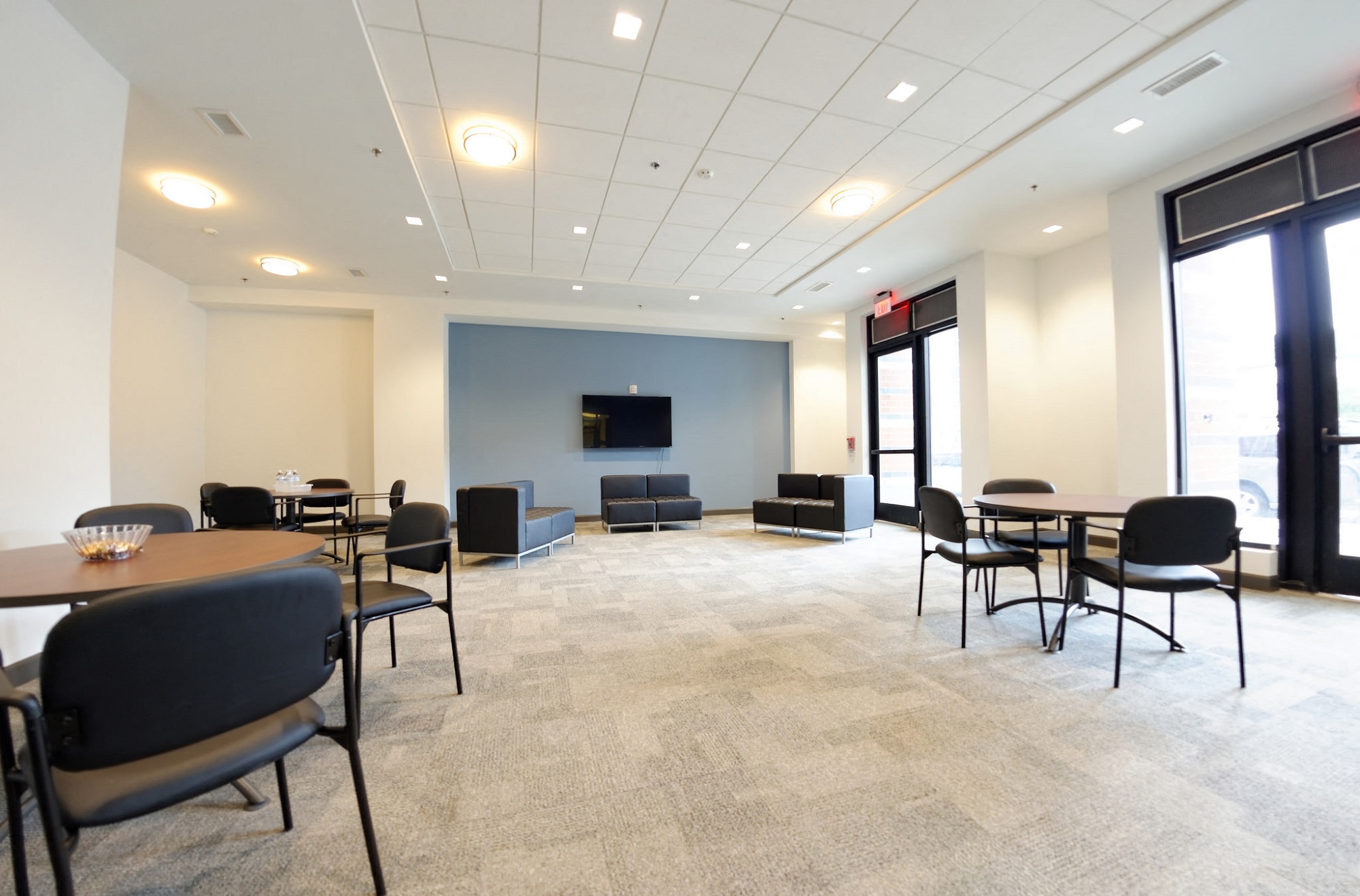 a large room with tables and chairs and a television