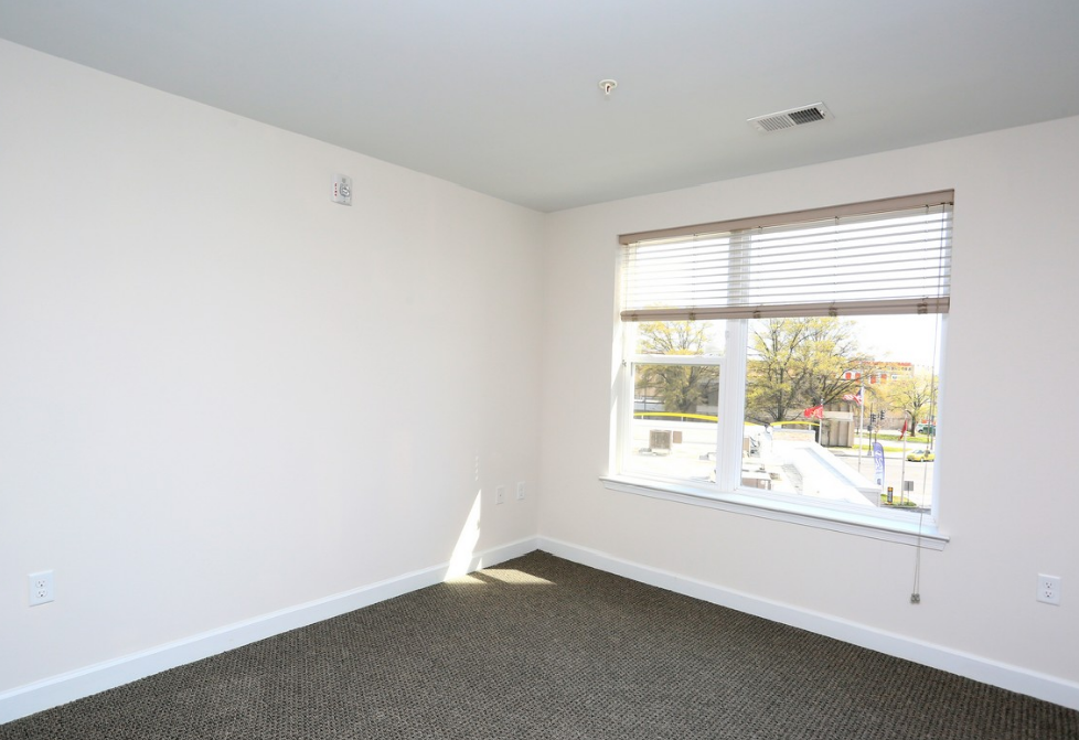 an empty room with a large window and white walls