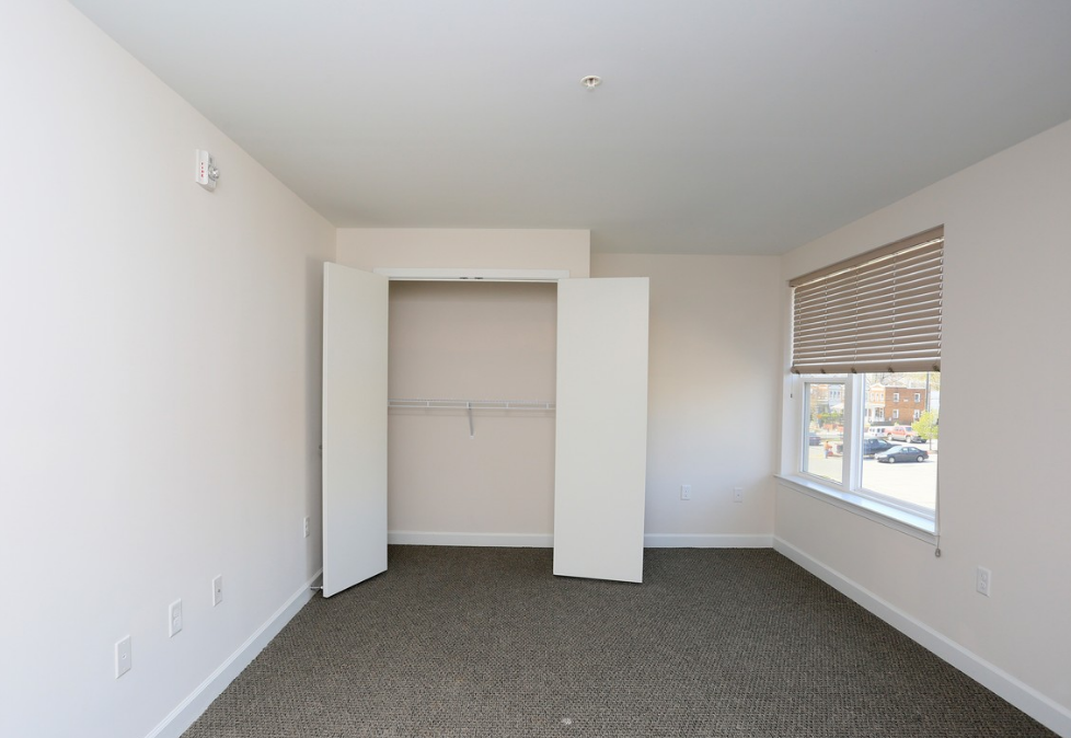 an empty room with white walls and a window