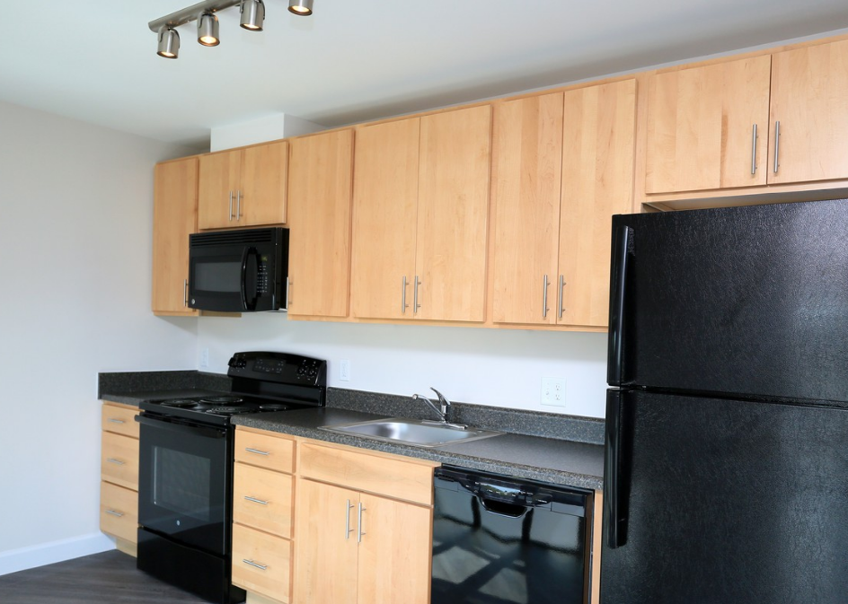 a kitchen with black appliances and wooden cabinets
