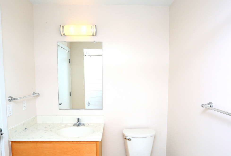 a bathroom with a toilet and a sink and a mirror