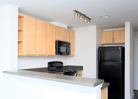 a kitchen with an island and a black refrigerator