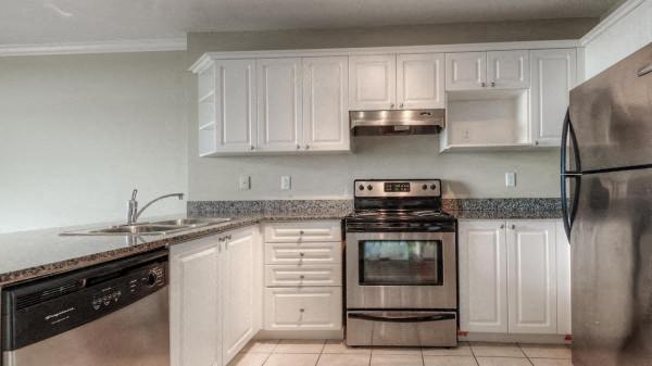 a kitchen with white cabinets and a stove and a refrigerator