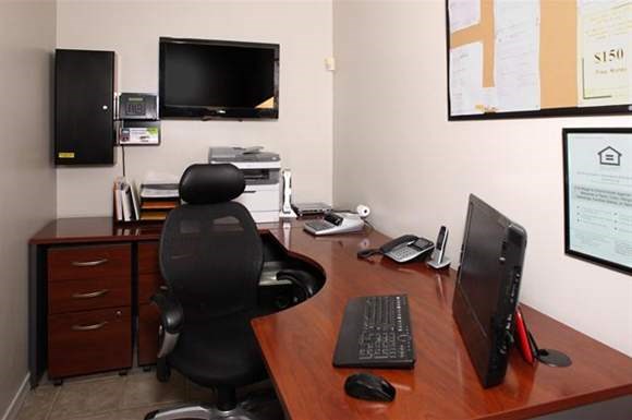 a desk with a computer monitor and a chair