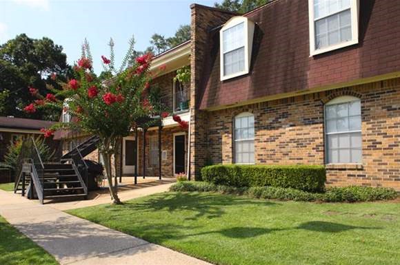 a brick house with a tree in the yard