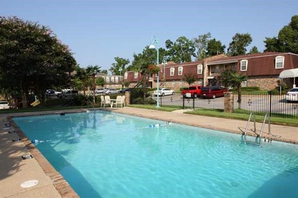a large swimming pool in front of an apartment building
