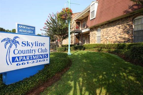 a skyline county club apartments sign in front of a house